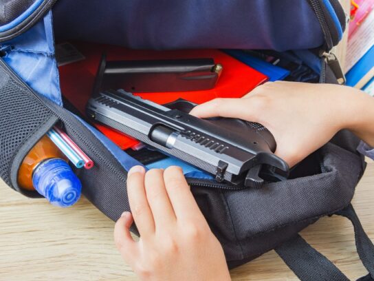 photo of student backpack open with a gun