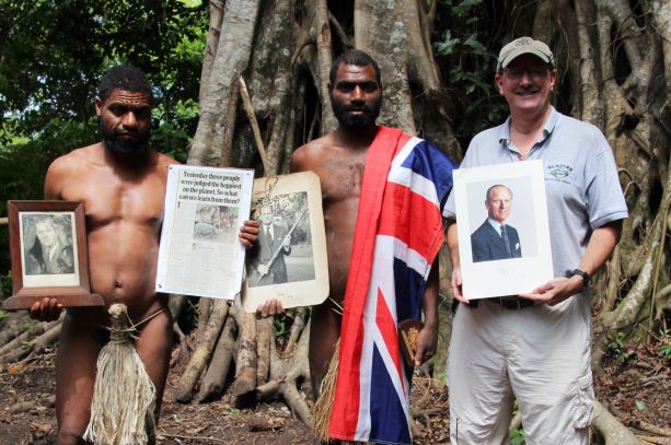 photo of Chief Linlin Jack Naiua, 27 years old, of Yaohnanen village on the island of Tanna in the South Pacific country of Vanuatu. He is holding a signed photo of Prince Philip with a pig-killing club/Toka dance stick from Tanna. Note the Chief’s demure penis sheath.
