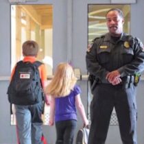 photo of school children and school resource office in school hallway