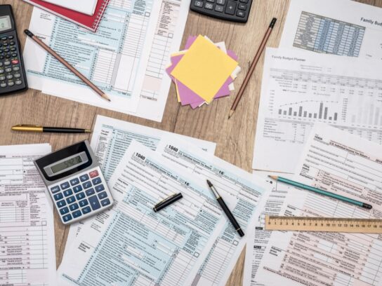 photo of saving concept tax form budget notepad-pen calculator