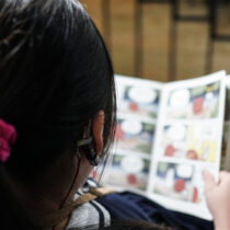 photo of young girl reading a comic book