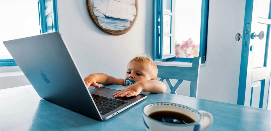 Photo of toddler reaching to work on a laptop