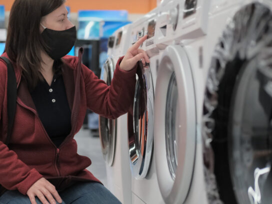 photo of girl in a medical mask buys a washing machine in a shop picture-id1291833232