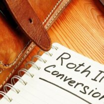 photo of notebook with message roth ira conversion on table next to a briefcase