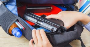 photo of student backpack open with a gun