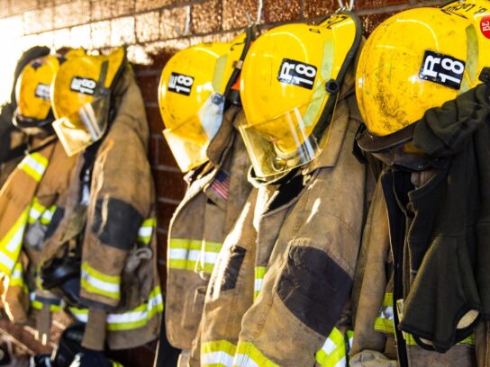 Firefighter equipment like helmets and clothing hanging up their shelves