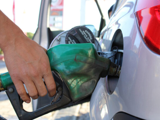 photo of hand holding gas pump filling car