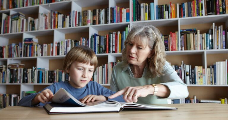photo of woman and grandson reading together in library