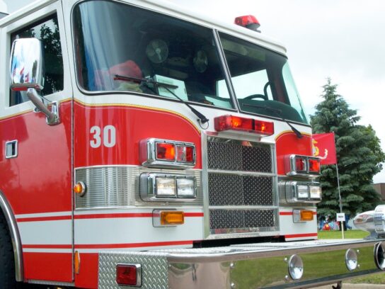 photo of fire truck parked on the road with stoppers around a wheel picture