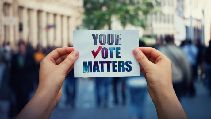 photo of hands hold a paper sheet with the message your vote matters