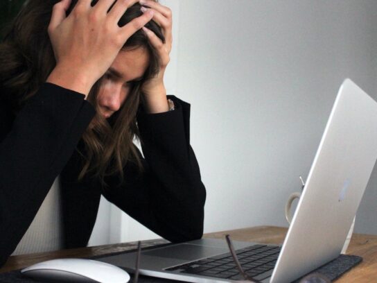 photo of stressed woman looking at laptop