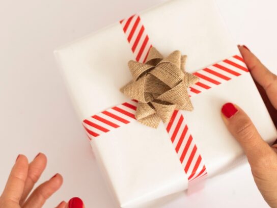 photo of hand holding wrapped gift