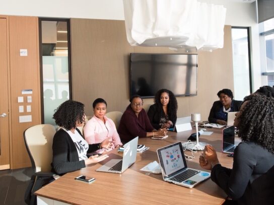 photo of adults at meeting with laptops