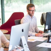 photo of young adults working on pcs or macs