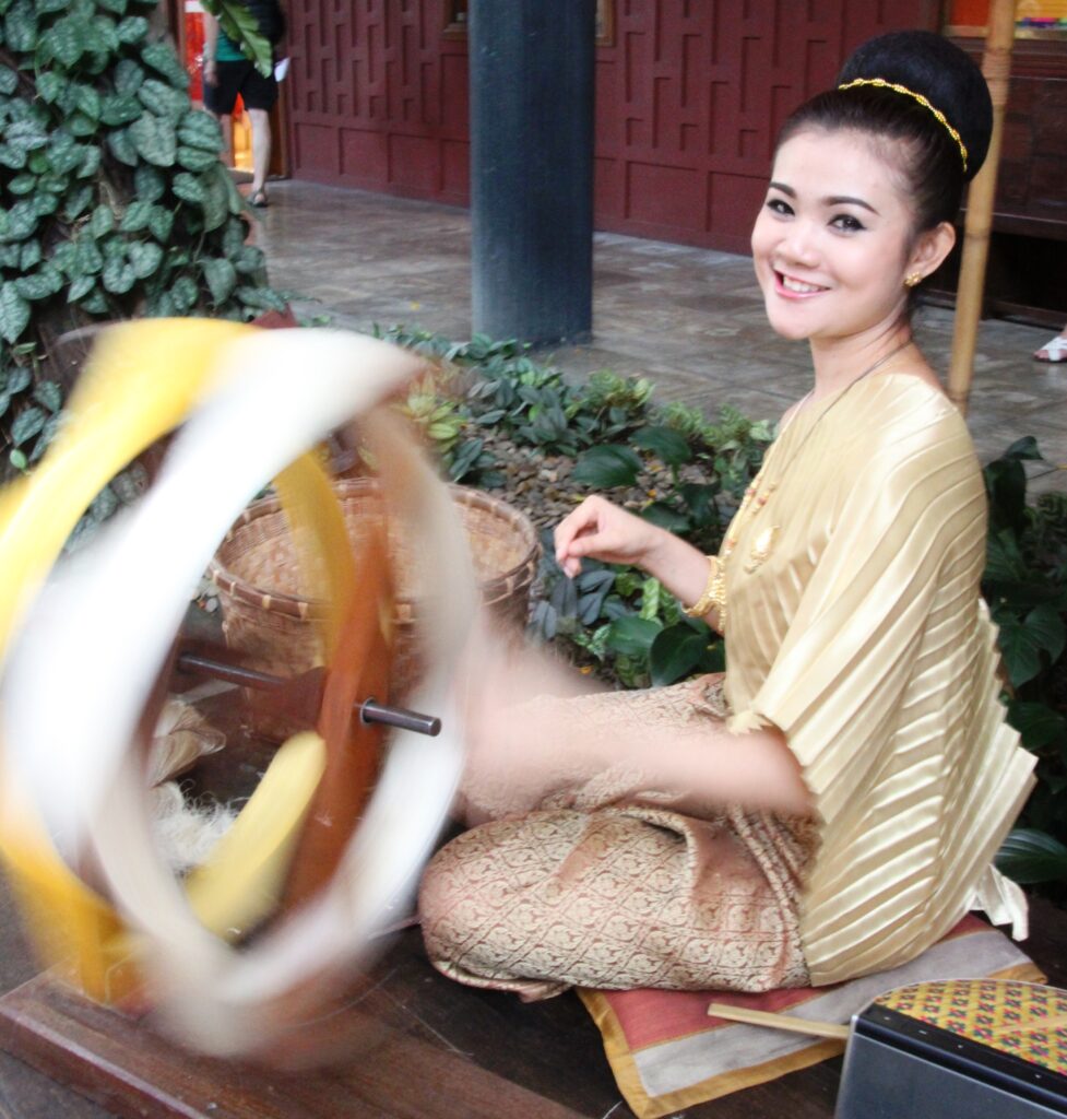 Thai girl at Jim Thompson house spinning silk