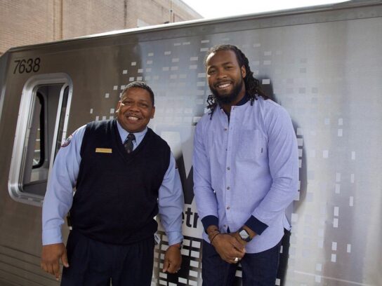 two metro employees in front of train