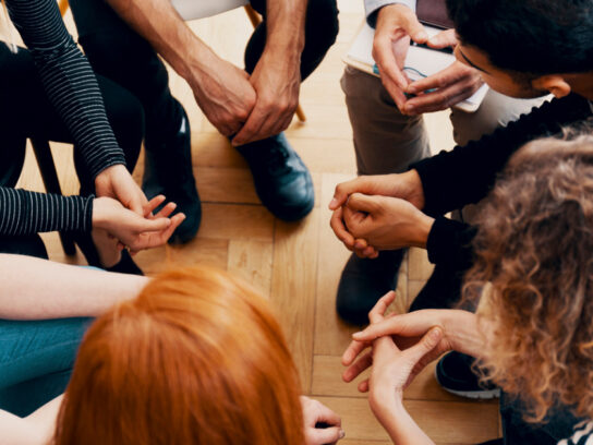 photo of group of teenagers sitting in a circle