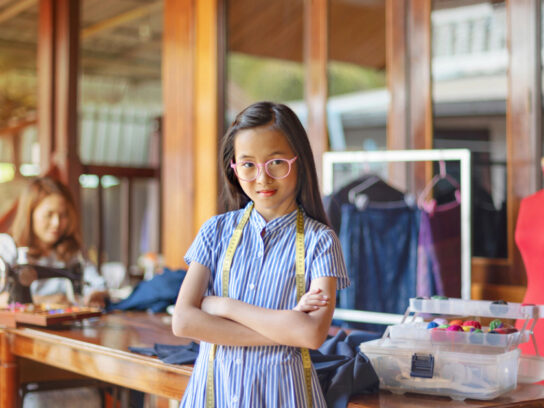 photo of young teen in charge of dress making workshop