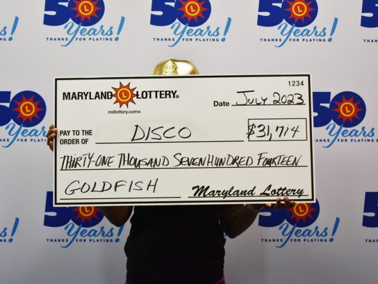 Photo of "Dicso" holding lottery check