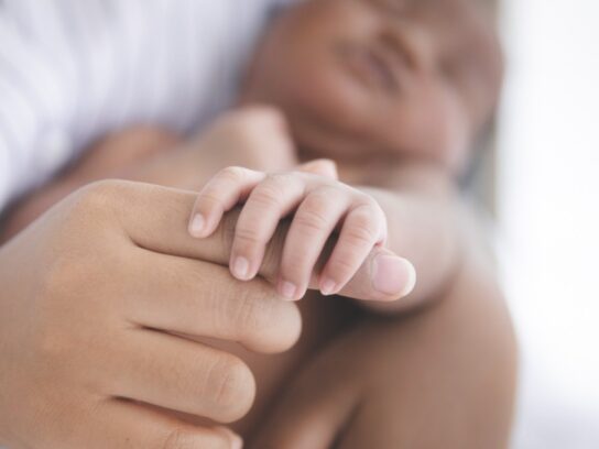 photo of Black mother holding infant's hand