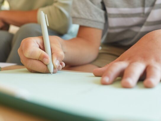 photo of middle school age boy doing homework writing